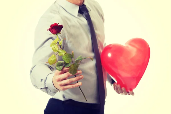 Hombre con una rosa roja y un globo del corazón . — Foto de Stock