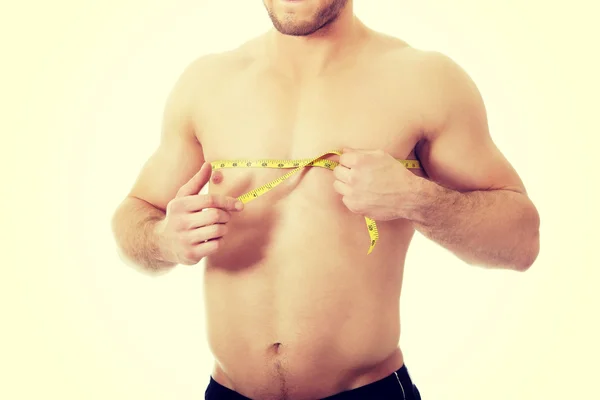 Мускулистый мужчина измеряет грудь . — стоковое фото