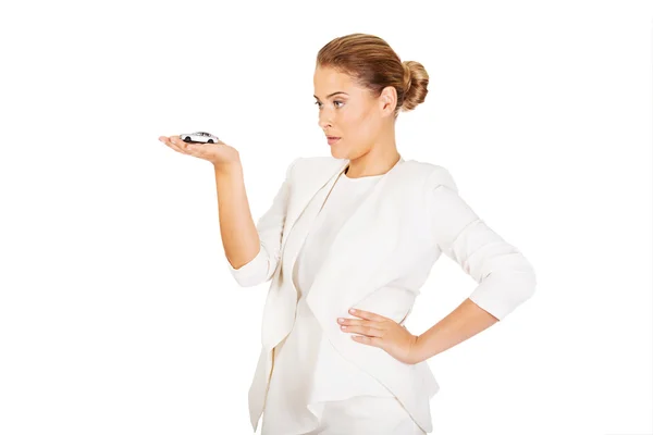Young businesswoman holding a toy car — Stock Photo, Image