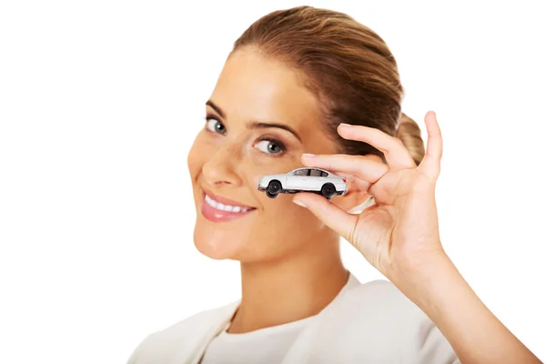 Young businesswoman holding a toy car — Stock Photo, Image