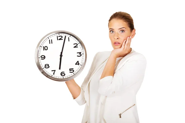 Здивована бізнес-леді тримає великий годинник — стокове фото