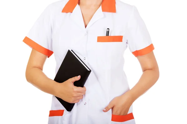 Young female doctor or nurse holding black notes — Stock Photo, Image