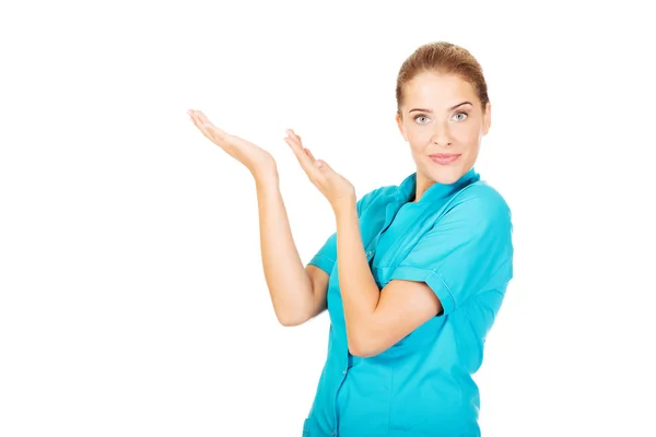 Giovane medico femminile mostrando qualcosa a mano — Foto Stock