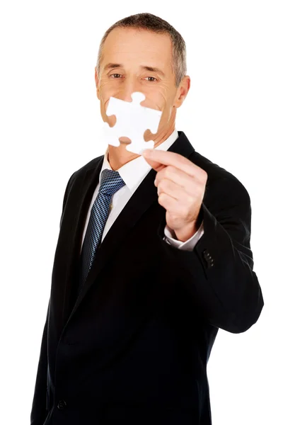 Smart businessman holding a puzzle — Stock Photo, Image