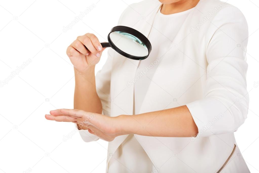 Businesswoman looking into a magnifying glass