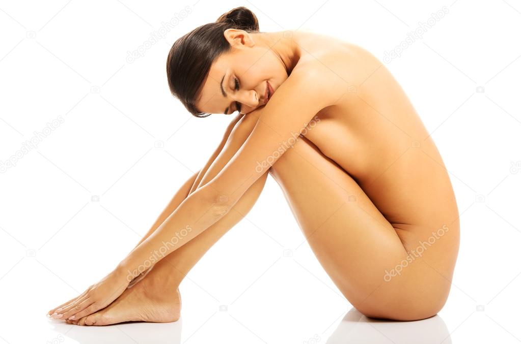 Nude woman sitting with head on knees