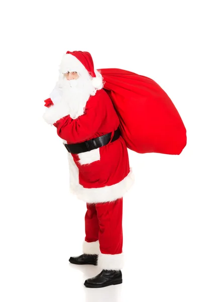 Santa Claus carrying bag with presents — Stock Photo, Image