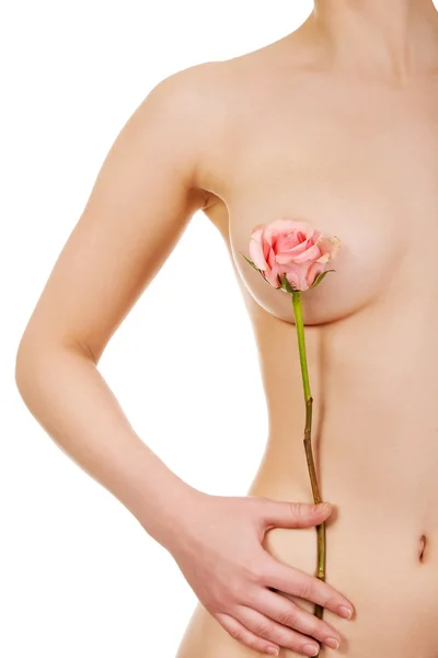 Woman covers breast with flower. — Stock Photo, Image