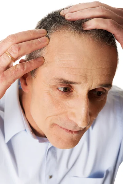 Uomo esaminando i suoi capelli — Foto Stock