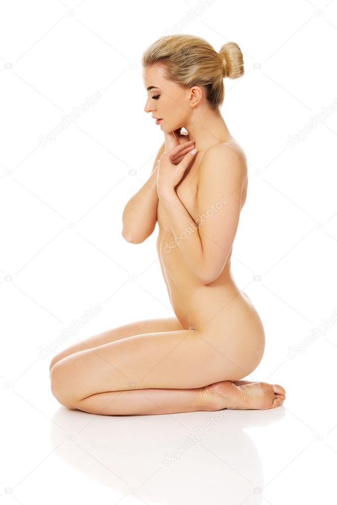 Young naked woman sitting on the floor