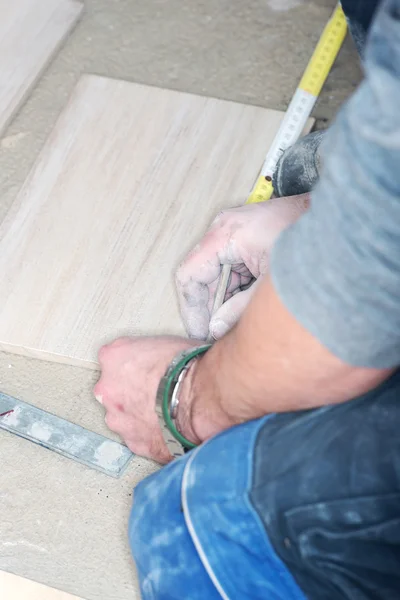 Tiler installs ceramic tiles — Stock Photo, Image