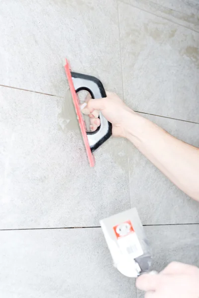 Tiler installs ceramic tiles — Stock Photo, Image