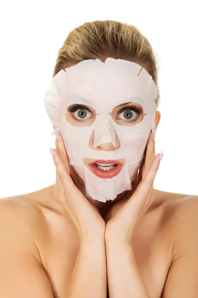 Young surprised woman with facial mask — Stock Photo, Image