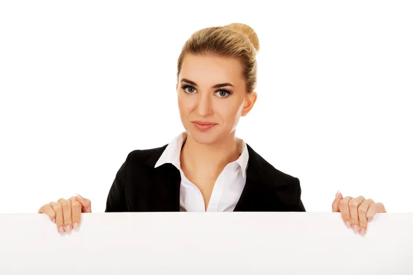 Mujer de negocios sonriente sosteniendo banner vacío —  Fotos de Stock