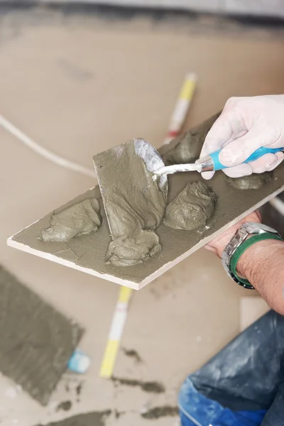 Tiler installs ceramic tiles — Stock Photo, Image