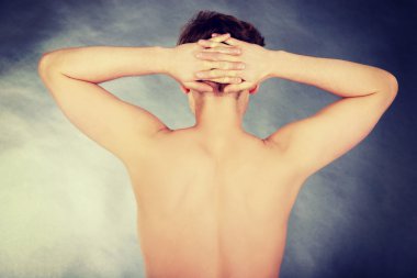 Elleri başının üstünde genç bir adam..