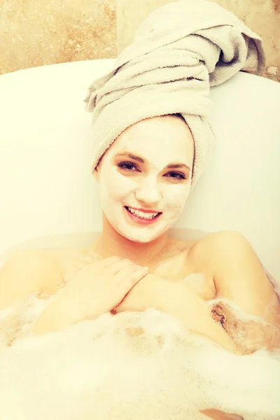 Mujer relajante en bañera con mascarilla facial . — Foto de Stock