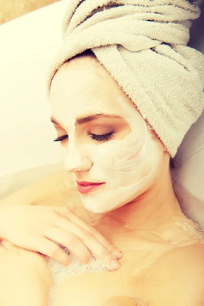 Mulher relaxante na banheira com máscara facial . — Fotografia de Stock