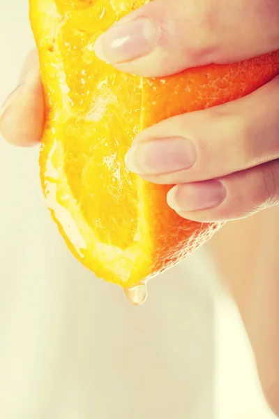 Женщина выжимает сок из апельсина — стоковое фото