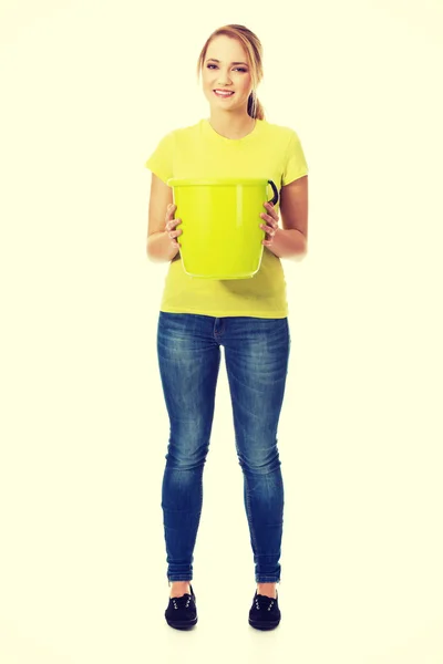 Mladá žena hospodářství zelená kbelík. — Stock fotografie