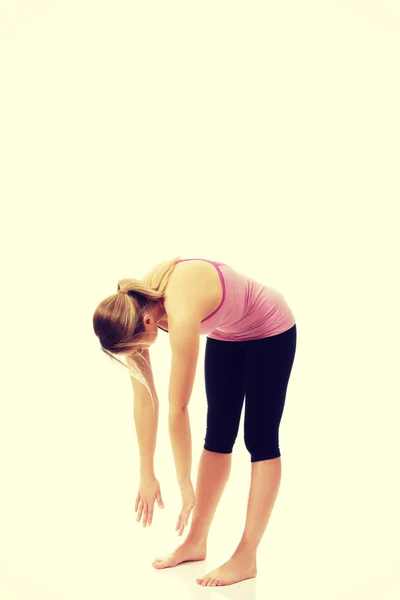 Mujer joven en pose de yoga doblado . —  Fotos de Stock