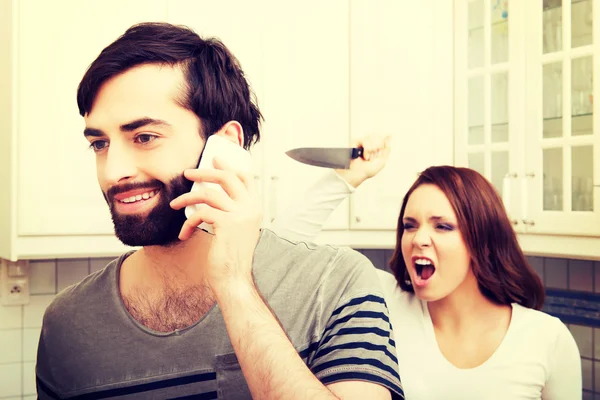 Angry young woman hitting men with frying pan. — Stock Photo, Image