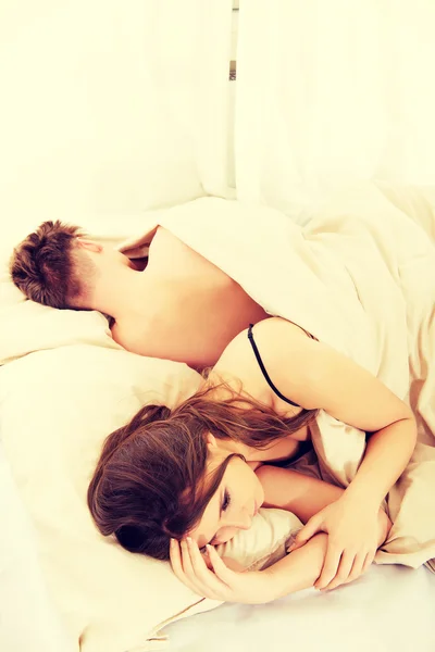 Thoughtful woman and sleeping man in bed. — Stock Photo, Image