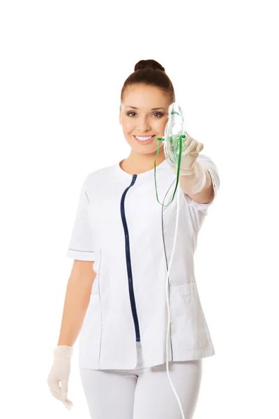 Female doctor holding up oxygen mask — Stock Photo, Image