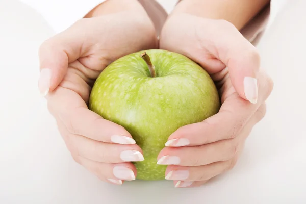 The big green apple in hands — Stock Photo, Image