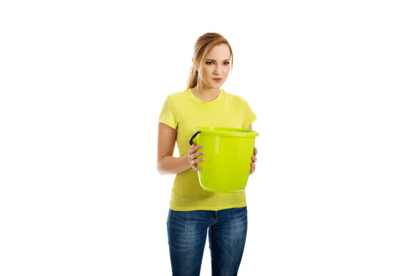 Young woman holding green bucket.