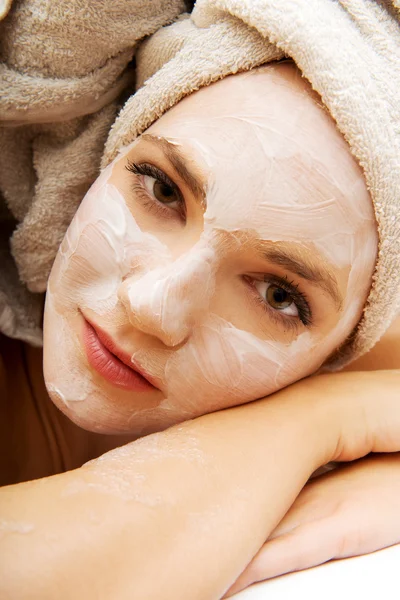 Frau entspannt sich im Badezimmer mit Gesichtsmaske. — Stockfoto