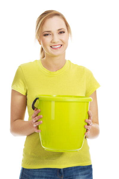 Young woman holding green bucket.