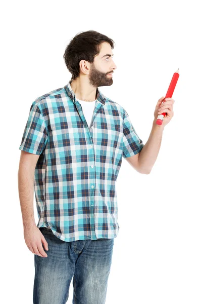 Jovem apontando com grande lápis vermelho . — Fotografia de Stock