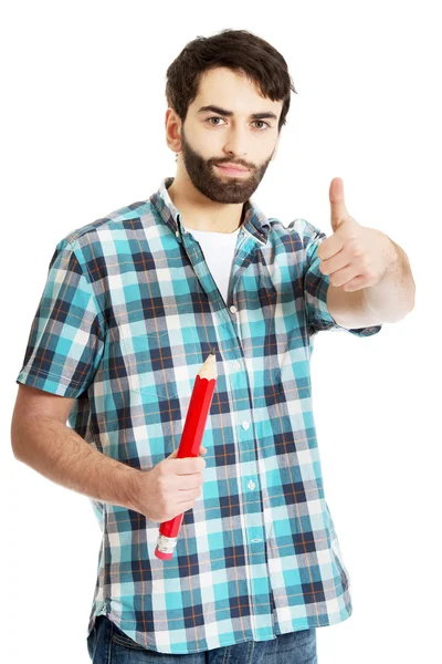 Joven sosteniendo un gran lápiz rojo . — Foto de Stock