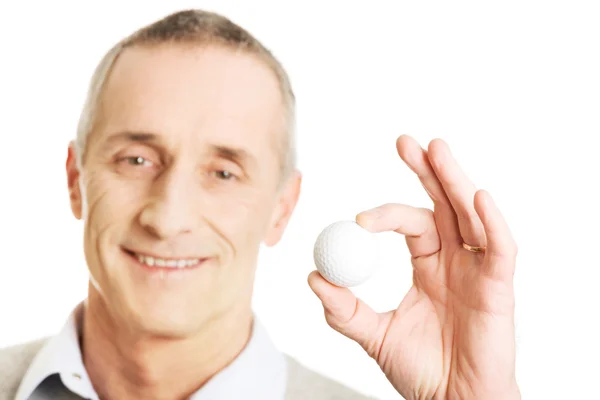 Mature man holding golf ball — Stock Photo, Image