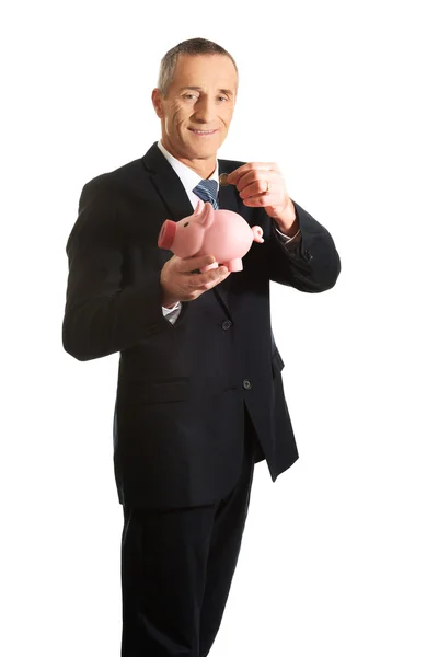 Веселый бизнесмен держит копилку — стоковое фото