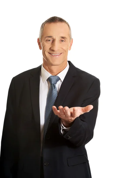 Businessman holding something on his palm — Stock Photo, Image