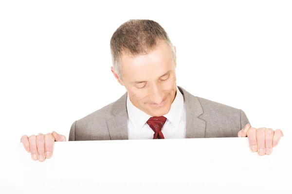 Зрілий бізнесмен тримає порожній банер — стокове фото