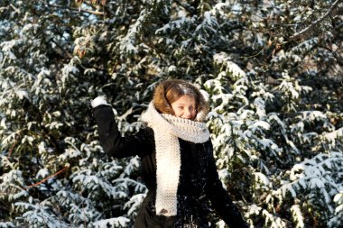 Young woman throwing snowball