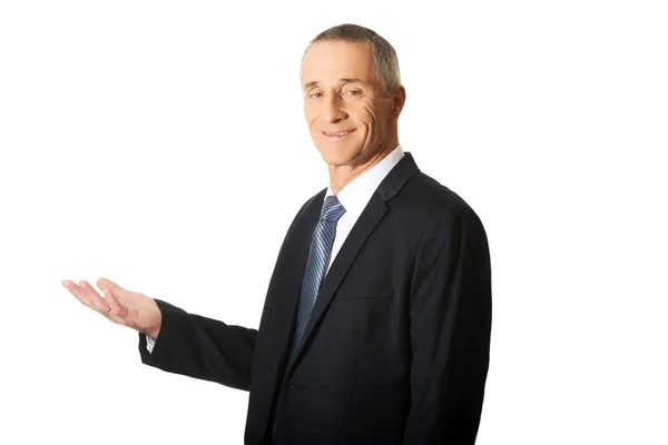 Businessman holding something on his palm — Stock Photo, Image