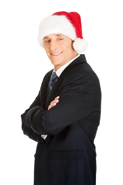 Hombre con los brazos cruzados usando sombrero de santa —  Fotos de Stock