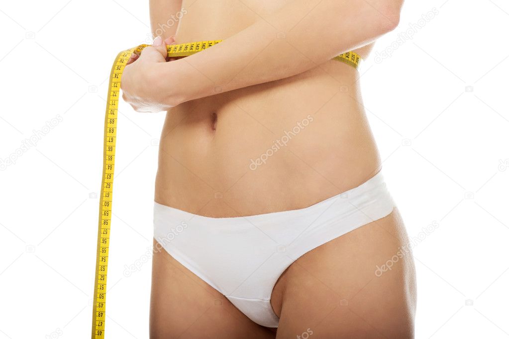 Slim woman measuring her waist.
