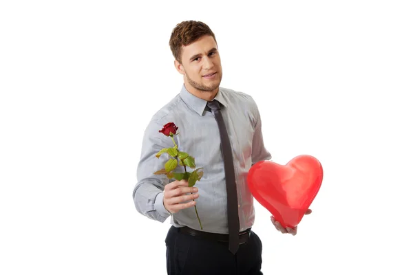 Hombre con una rosa roja y un globo del corazón . — Foto de Stock