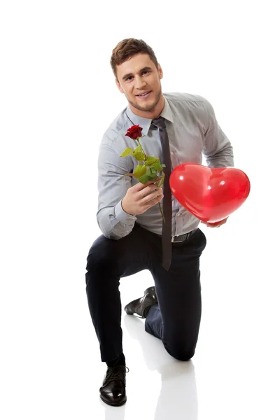 Man kneeling with red rose — Stock Photo, Image