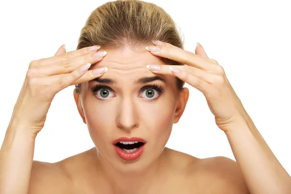 Vrouw controleren rimpels op haar voorhoofd — Stockfoto