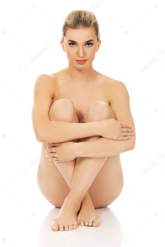 Young naked woman sitting on the floor