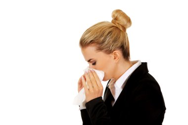 Businesswoman with an allergy sneezing into tissue clipart
