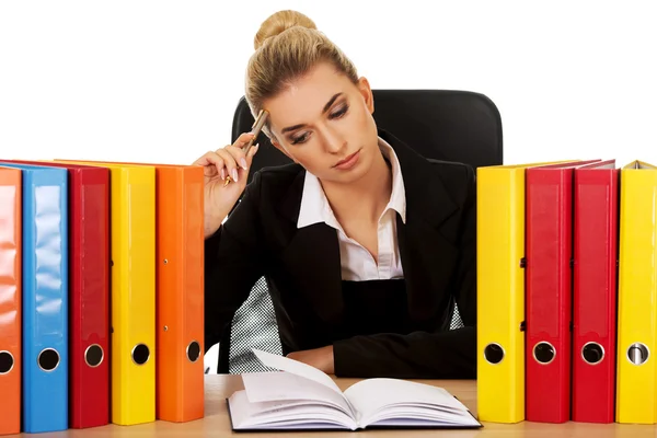 Mujer de negocios agotada con carpetas detrás del escritorio — Foto de Stock