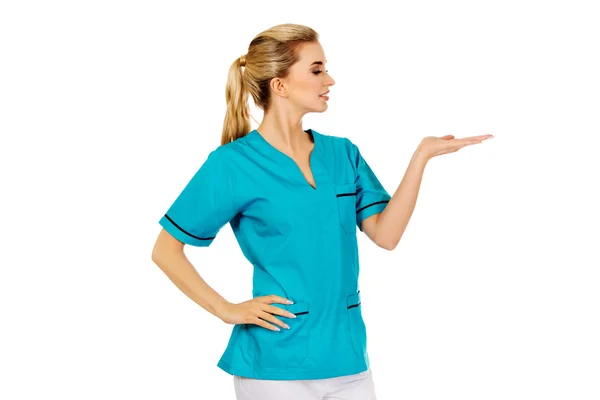 Mujer sonriente médico o enfermera señalando algo —  Fotos de Stock