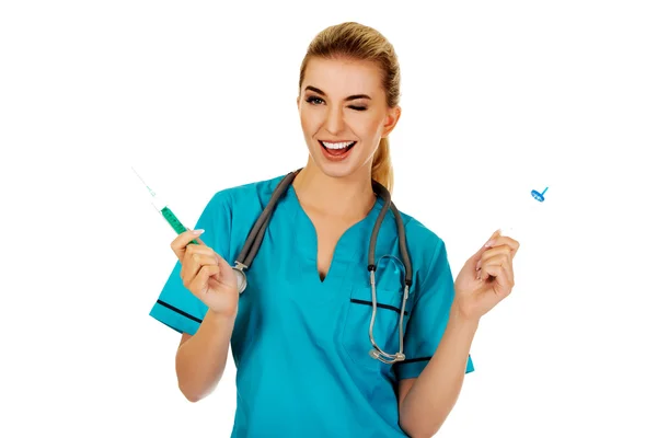 Infirmière souriante avec deux seringues dans les mains — Photo